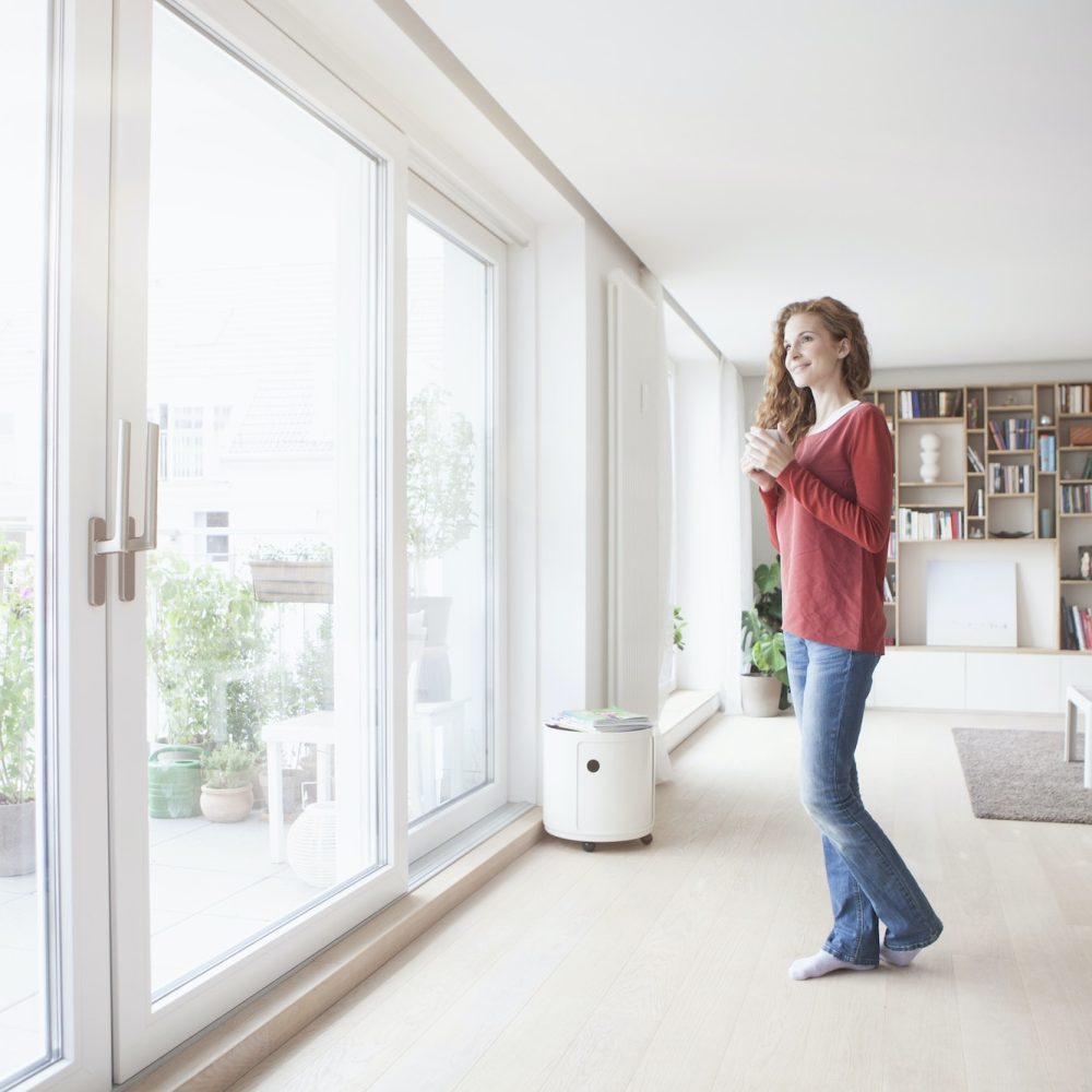 Woman at home looking out of window